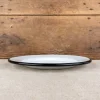 Assiette en émail blanc liseré noir