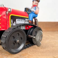 Tracteur mécanique rouge et son chauffeur