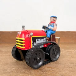 Tracteur mécanique rouge et son chauffeur