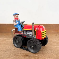 Tracteur mécanique rouge et son chauffeur